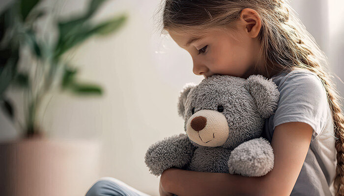 Trauriges Mädchen hält Teddy