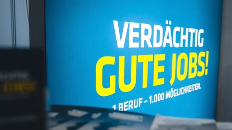 Das Logo der Berufskampagne »Verdächtig gute Jobs!« bei einem Messeauftritt. Das Polizeipräsidium für Service und IT (PPSI) informiert auch auf solchen Veranstaltungen über zivile Jobs und Karrieremöglichkeiten sowie die Bewerbung.