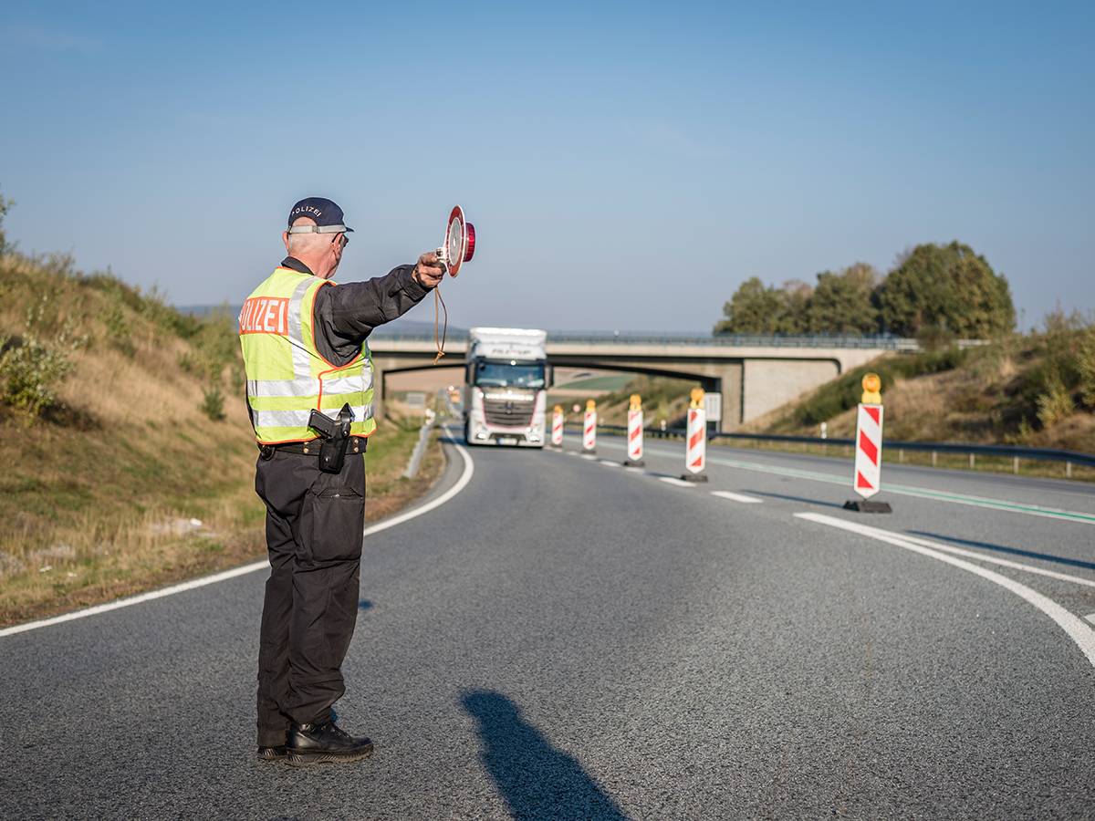 Ein Polizist gibt Anweisungen per Haltekelle.