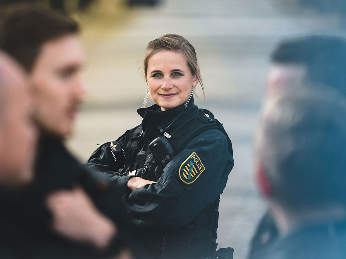 Eine Polizistin steht hinter ihren Teamkollegen