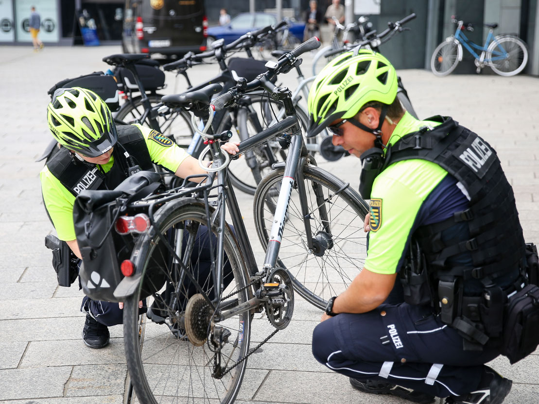 Polizeibeamte kontrollieren ein Fahrrad.