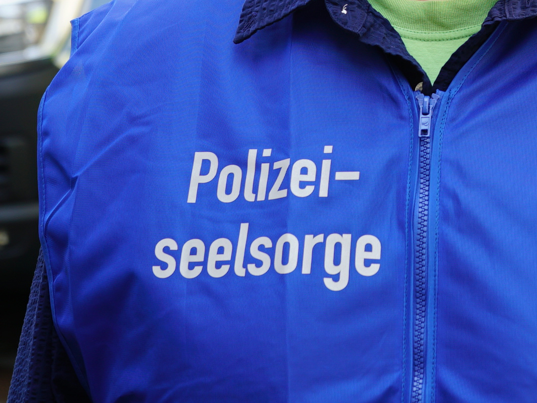 Polizist mit blauer Polizeiseelsorger-Weste