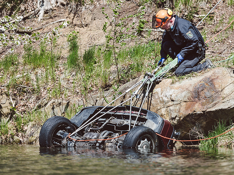 Polizeitaucher ziehen das Fahrzeug aus dem Wasser.