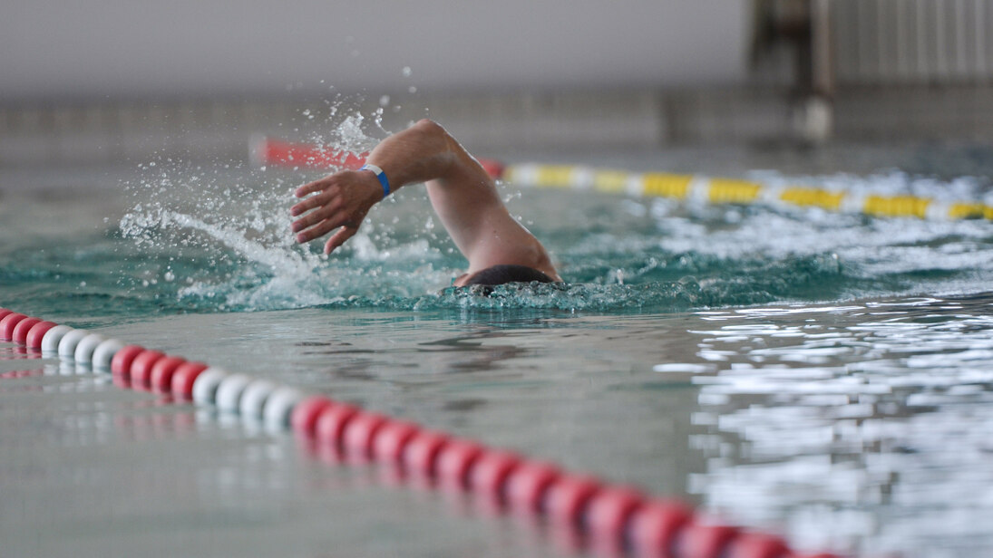 Person schwimmt im Schwimmbecken