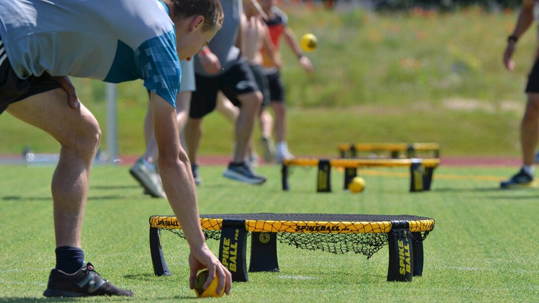 Person hebt den Ball auf